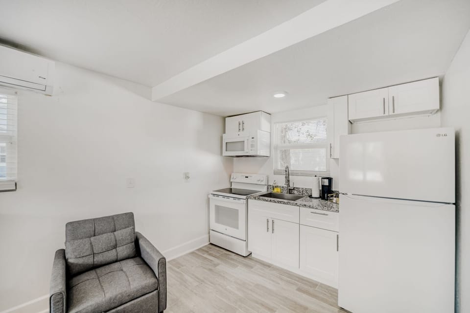 Relaxing lounge space provides a comfy armchair and open views of the kitchen, ideal for unwinding with a book or streaming your favorite shows.