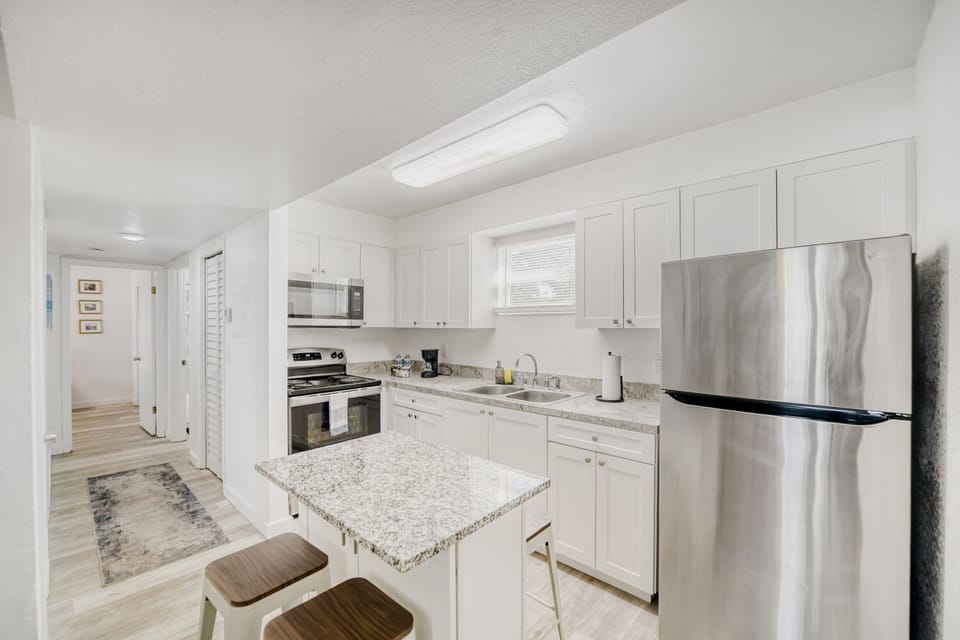 Sleek kitchen boasts stainless steel appliances, granite countertops, and breakfast bar seating for effortless dining and cooking.