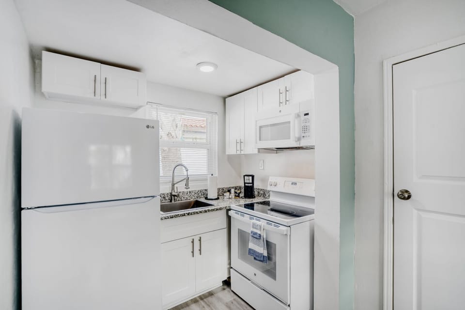 Well-appointed kitchen includes a full-size fridge, microwave, oven, and coffee maker, offering everything needed for homemade meals.
