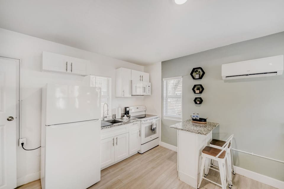 Sleek kitchen offers a refrigerator, oven, stovetop, microwave, and breakfast bar, making home-cooked meals a breeze in a bright, welcoming space.
