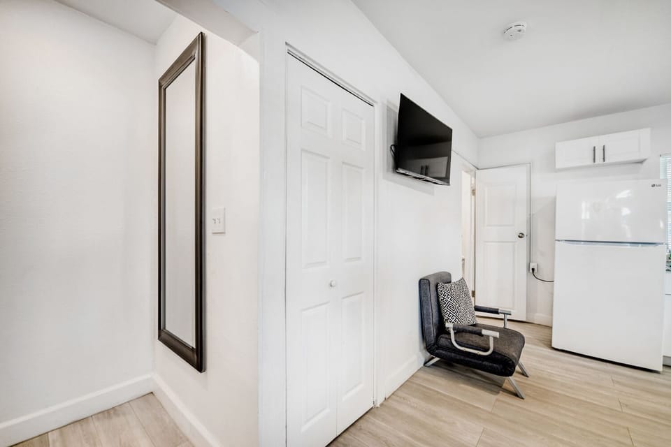 Entryway includes a large mirror, flat-screen TV, and thoughtful seating, blending style and functionality for a seamless guest experience.