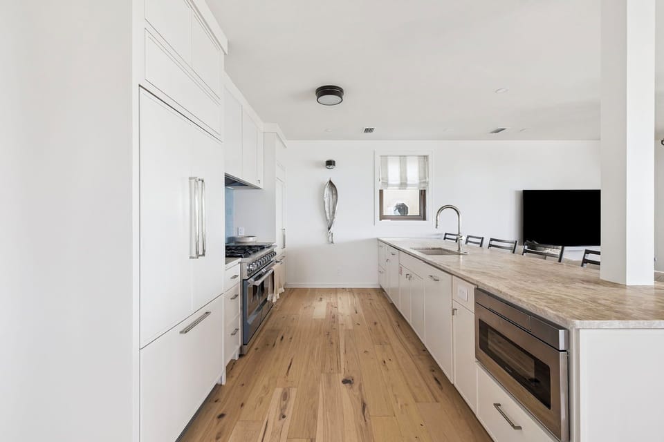 Your modern kitchen features marble countertops, stainless appliances, and warm wood floors—perfect for preparing memorable meals together.