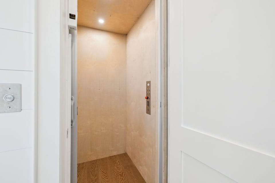 Step into your private elevator for effortless access to your floor, complete with modern controls and warm wood finishes.