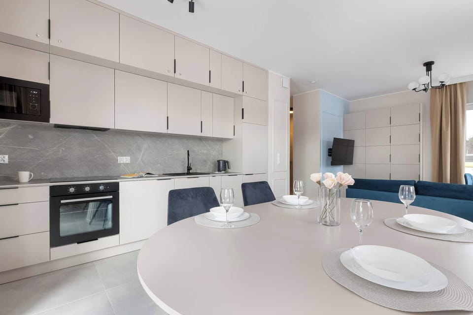 The kitchenette and dining area are captured in one frame, highlighting the ergonomic layout and the abundance of storage. This view demonstrates how the apartment is perfectly suited for both short stays and longer visits.