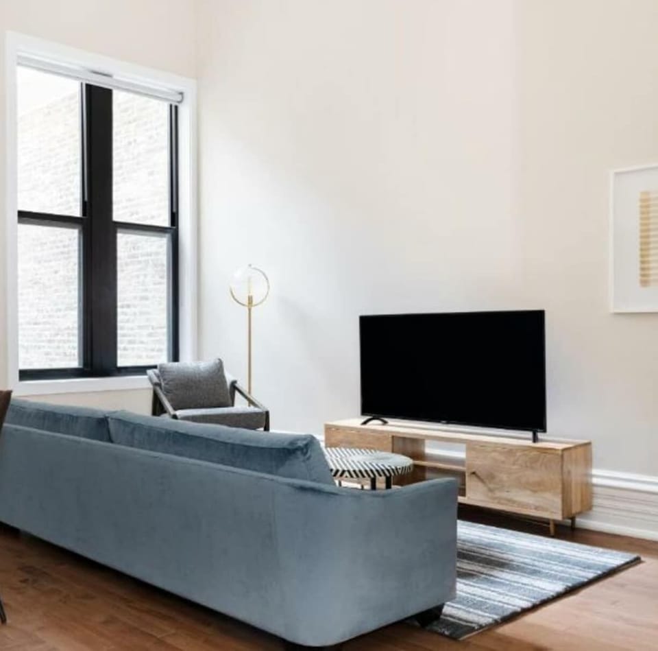 Open living area with sofa, 50 inch smart TV, and modern decor