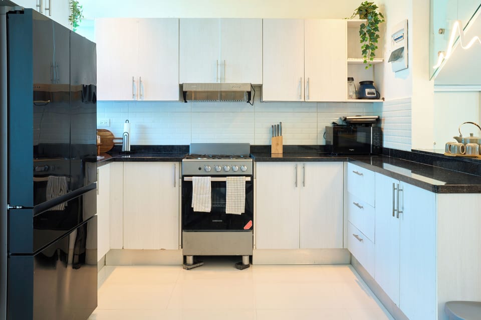 Modern fully equipped kitchen with stove, oven, range hood, and ample storage sp
