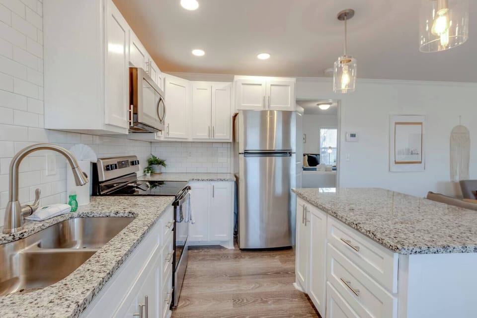Kitchen showing the sink area, granite countertops, and stainless steel refrigerator