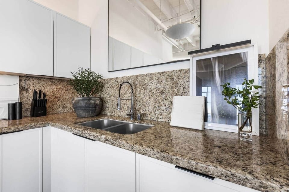 Double sinks with a view of stunning high ceilings and an elegant mirror backsplash.