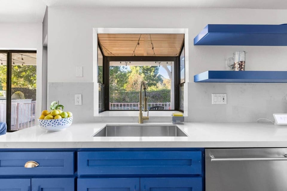 Deep sink and a charming woven wood window shade offer a relaxing spot for cleanup with a view.