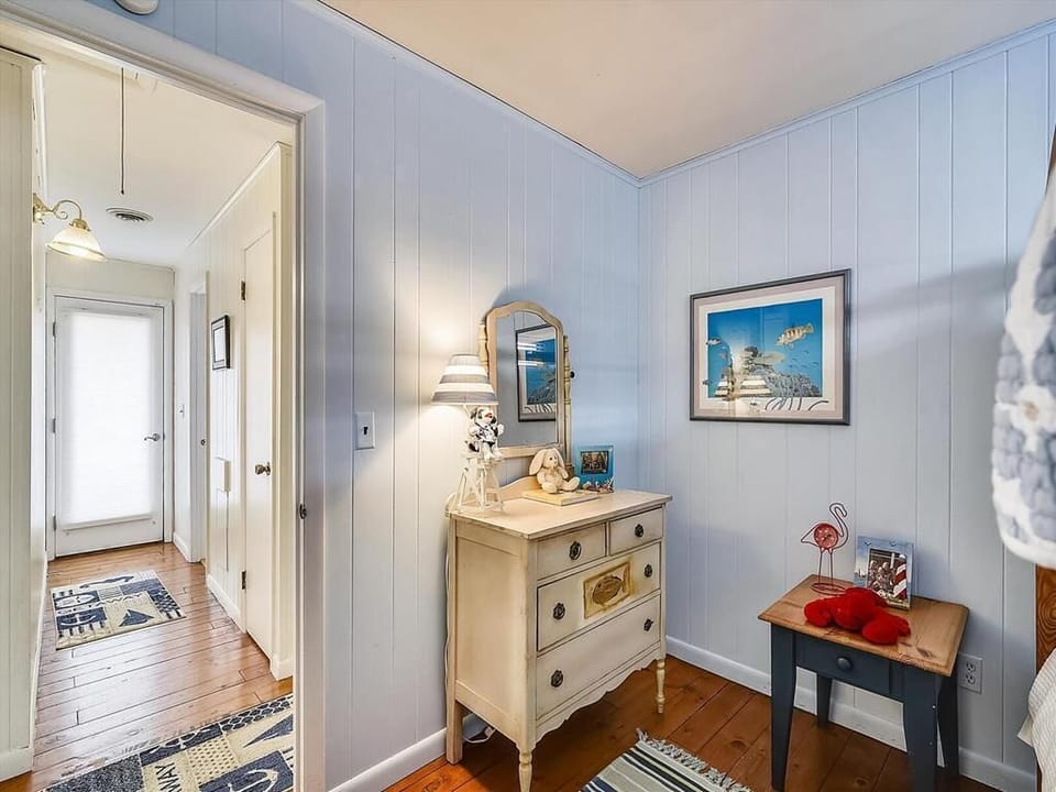 A bright hallway adorned with beach-themed decor and warm lighting leads you to the heart of the home, welcoming family and friends alike.