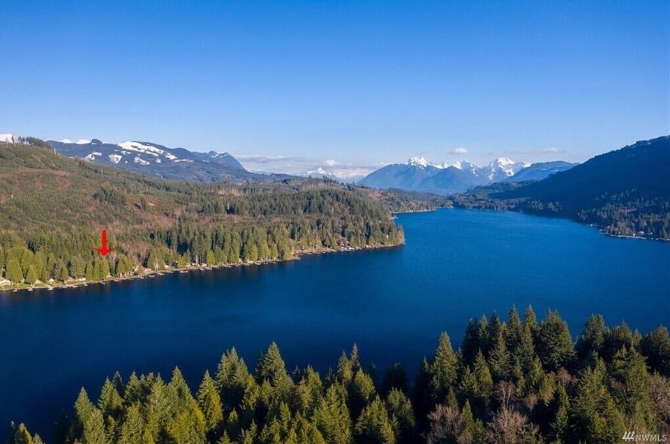Aerial view of the lake, with the house marked by a red arrow.