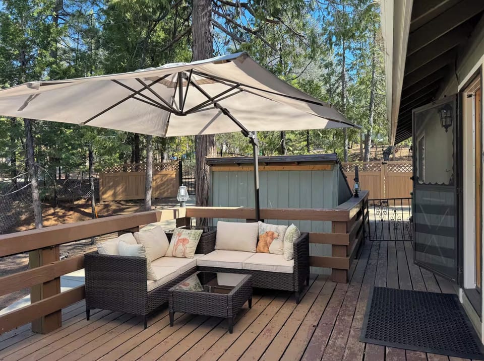 Peaceful forest deck with outdoor seating and umbrella—perfect for relaxing. 🌲☀