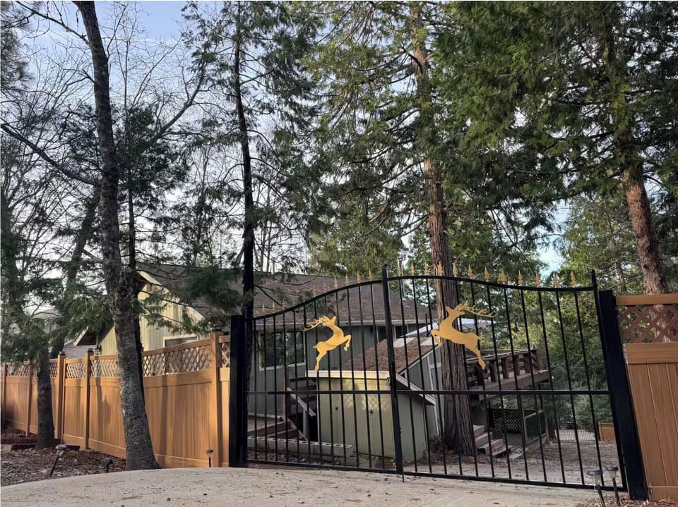 Private forest entrance with custom deer gate at peaceful Cedar Ridge Retreat.