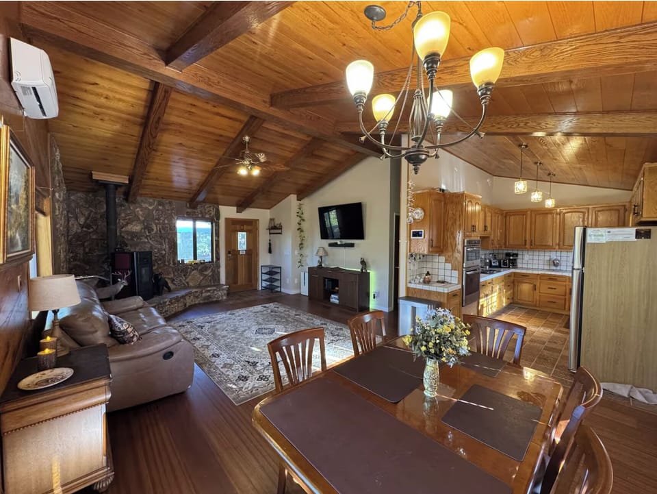 Spacious open living area with vaulted wood ceilings and full kitchen.