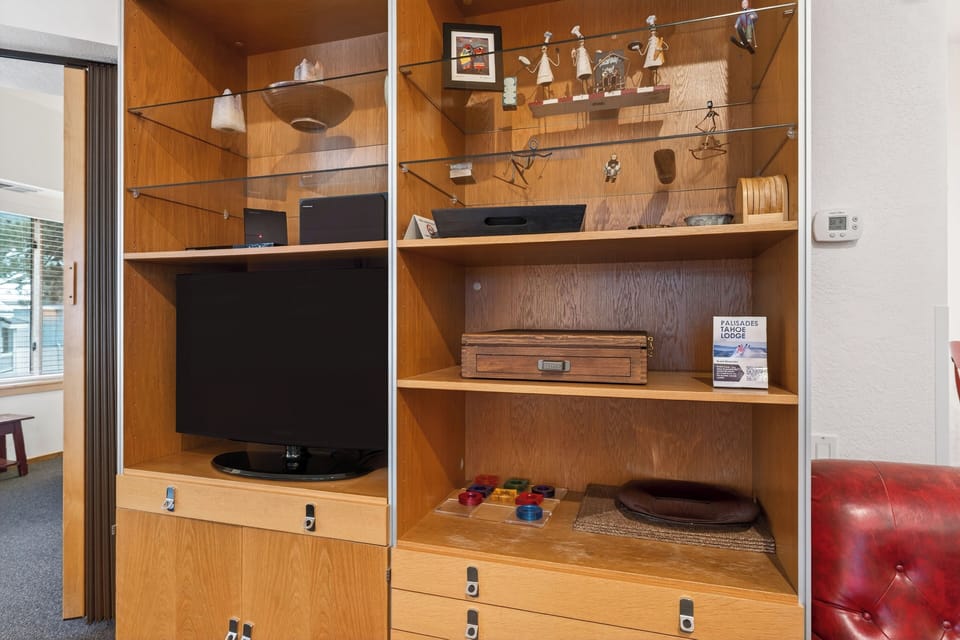 Built-in entertainment center with TV, board games, and curated décor — perfect for cozy movie nights and laid-back evenings in.