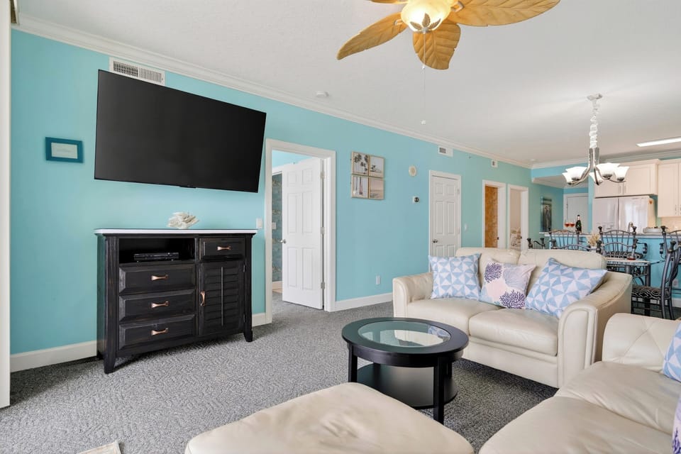 Cozy living room with ocean-view balcony—kick back inside, then step out for salty breezes and endless blue.