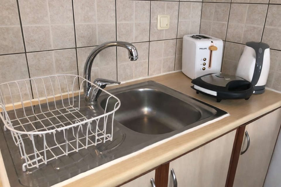 Modern kitchenette with a sink, kettle, stove, small oven and essential appliances for preparing light meals and breakfast. A practical space designed for convenience, allowing guests to enjoy simple cooking during their stay