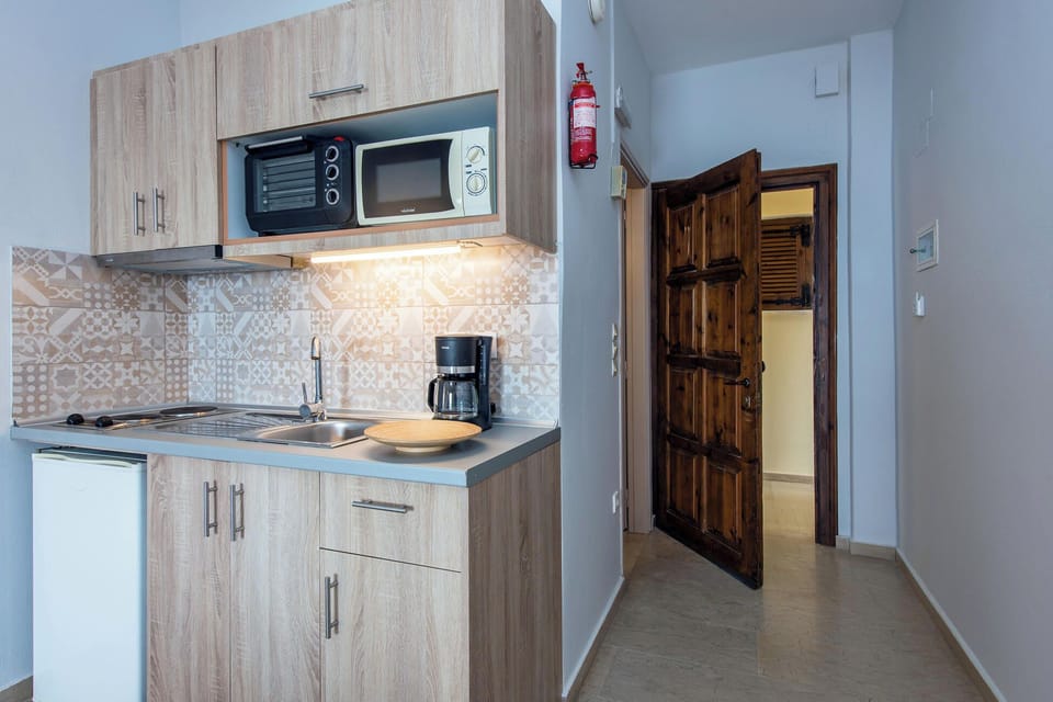 Compact kitchenette equipped with essential amentities, perfect for preparing light meals during your stay.
