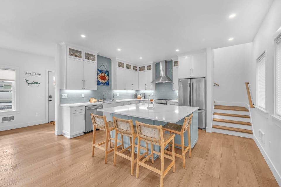 Your gourmet kitchen features sleek white cabinets, quartz countertops, and a spacious island perfect for cooking and casual dining together.