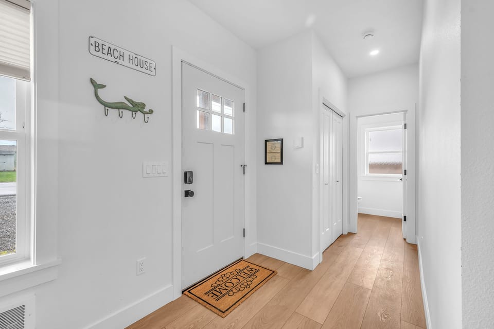 Step into your bright, welcoming entryway with charming coastal touches and warm hardwood floors that flow throughout your beach retreat.