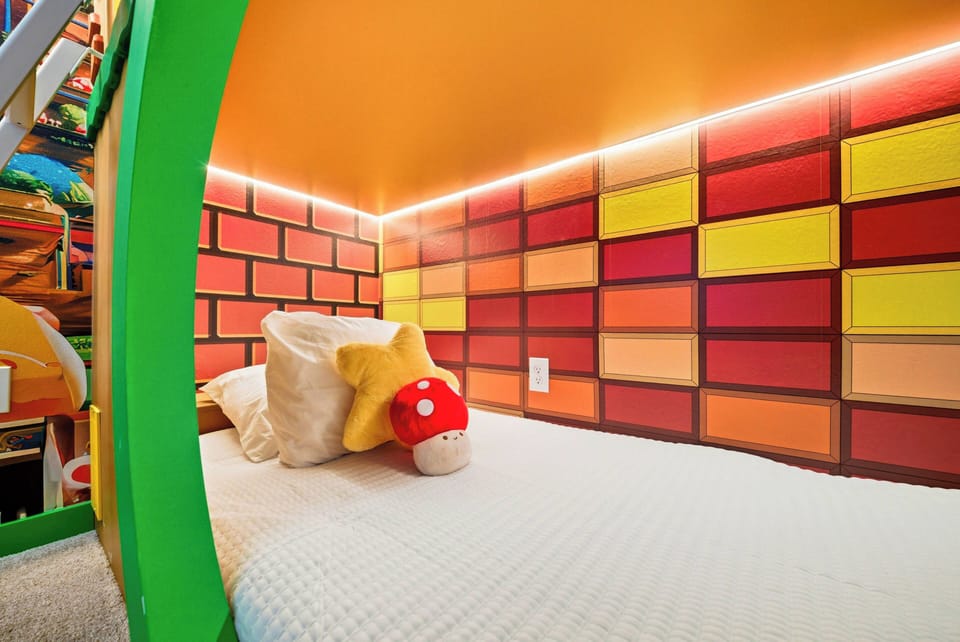 Step into a playful haven with bright orange walls and a whimsical brick design that sparks creativity. The cozy bedding features a charming star and playful plush, inviting children to dream big in this fun-filled corner.