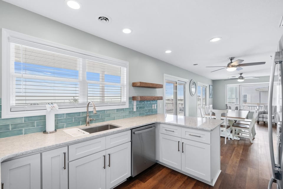 Bright, modern kitchen with ocean-inspired backsplash and open layout