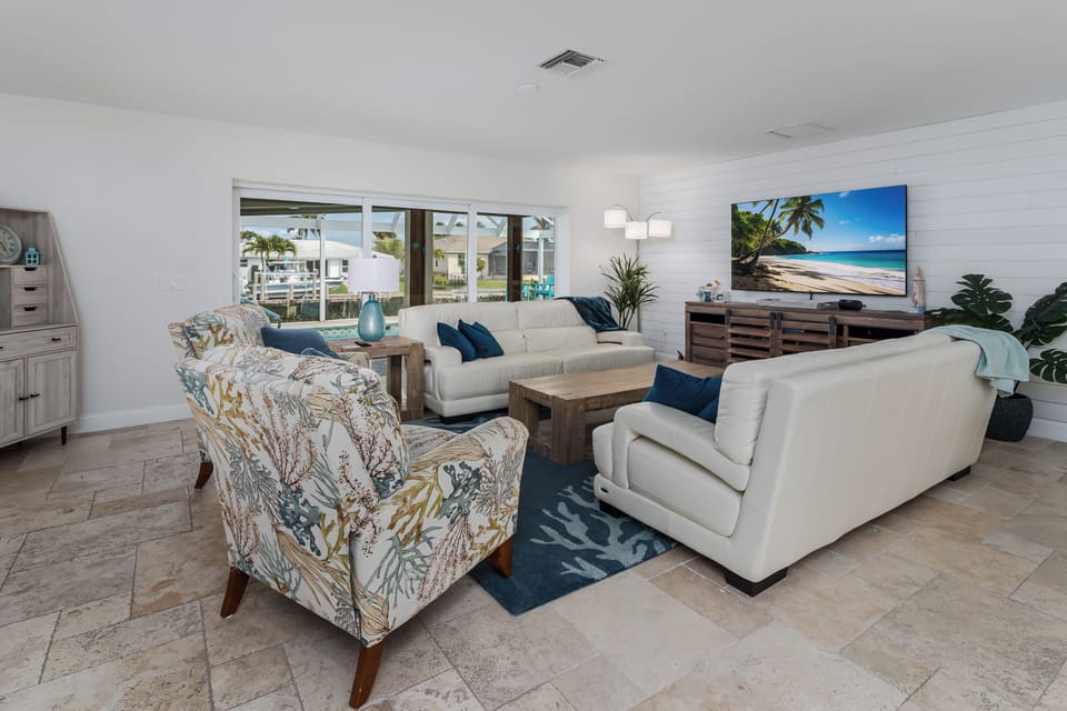 Sink into plush white sofas and watch tropical beach scenes on the large TV while natural light streams through waterfront windows.