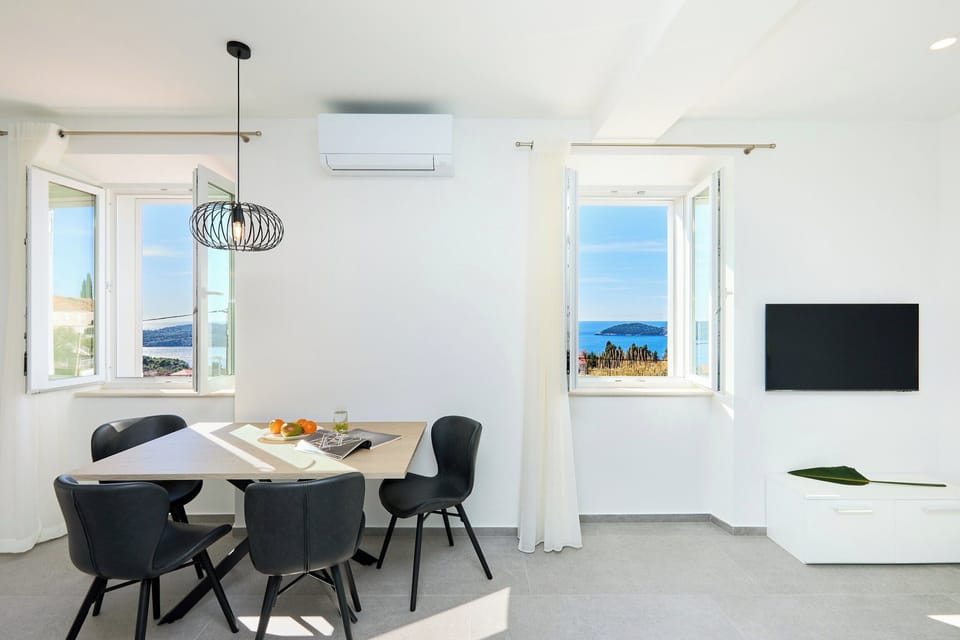 Enjoy meals with a breathtaking sea view in this bright, air-conditioned dining area. Sunlight streams through open windows, illuminating the modern décor.