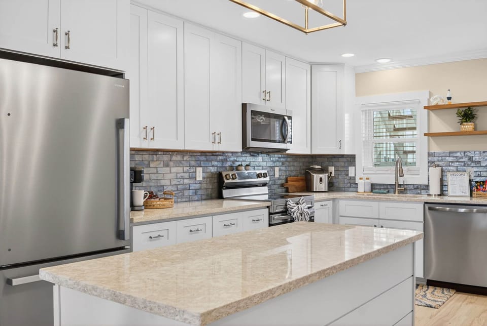 Bright modern kitchen with large island and stainless steel appliances