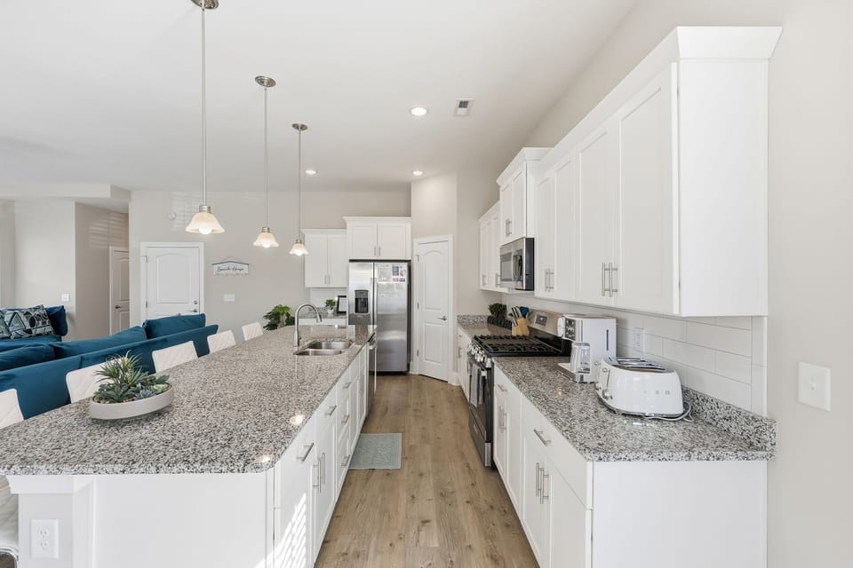 Modern coastal kitchen with island seating and well stocked for extended stays and family vacations.