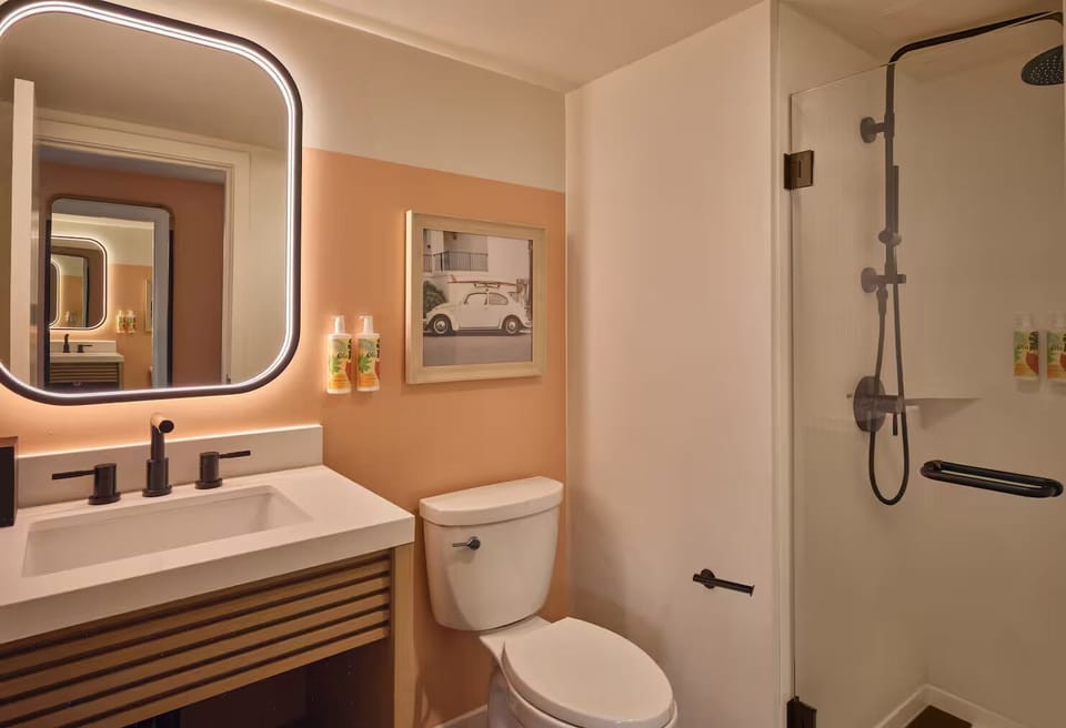 Refresh in a bright, modern bath with glowing mirror.