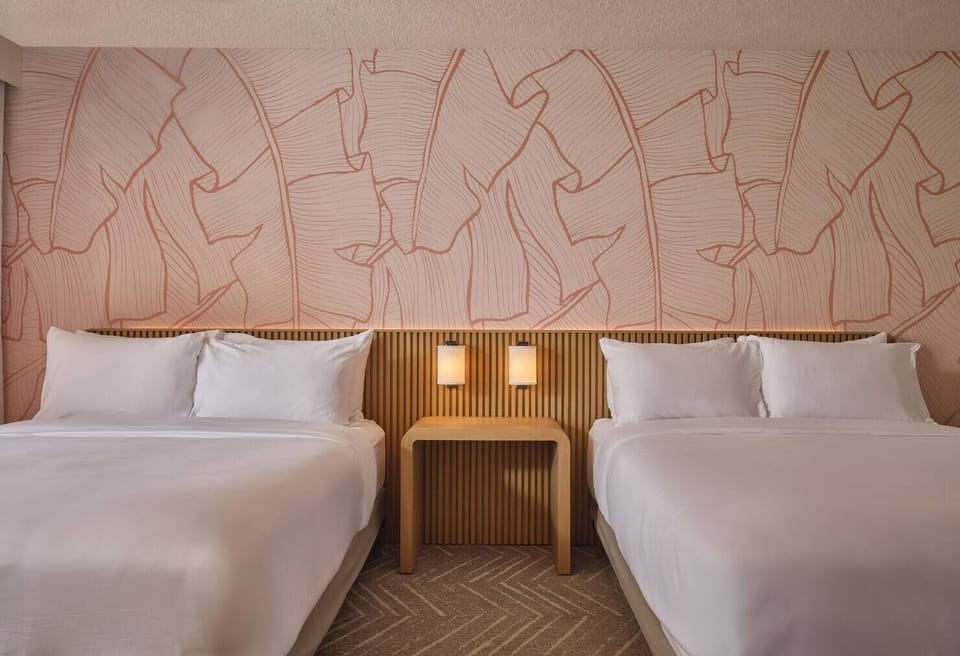 Drift off in serene symmetry with soft lamps and crisp bedding.