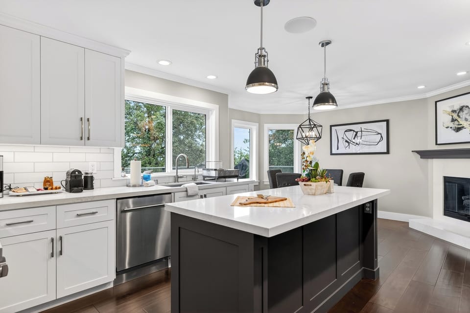 Bright chef's kitchen with a large center island and stainless steel appliances.