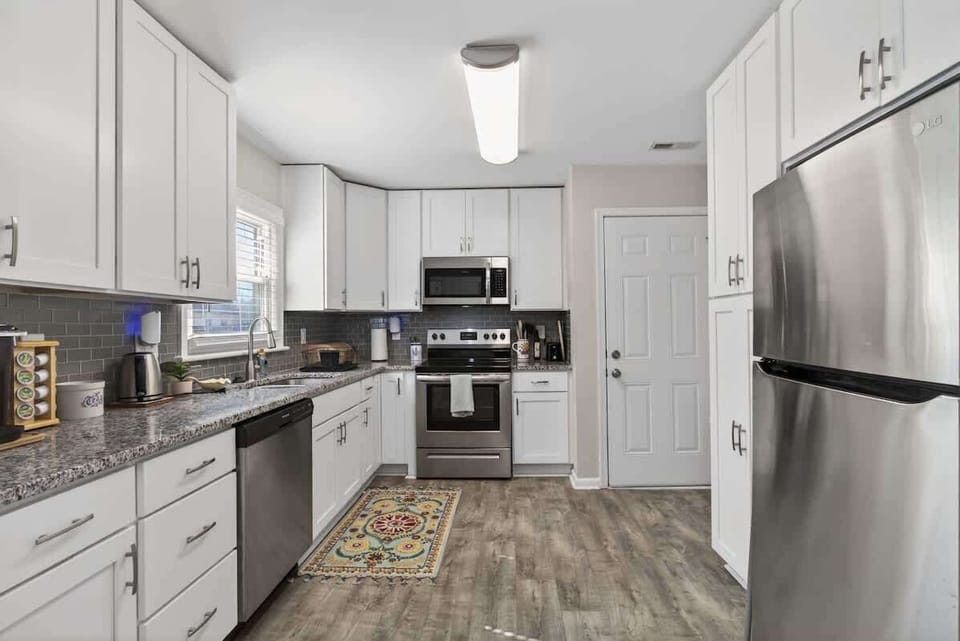 Fully equipped kitchen featuring stainless steel appliances and ample counter space.