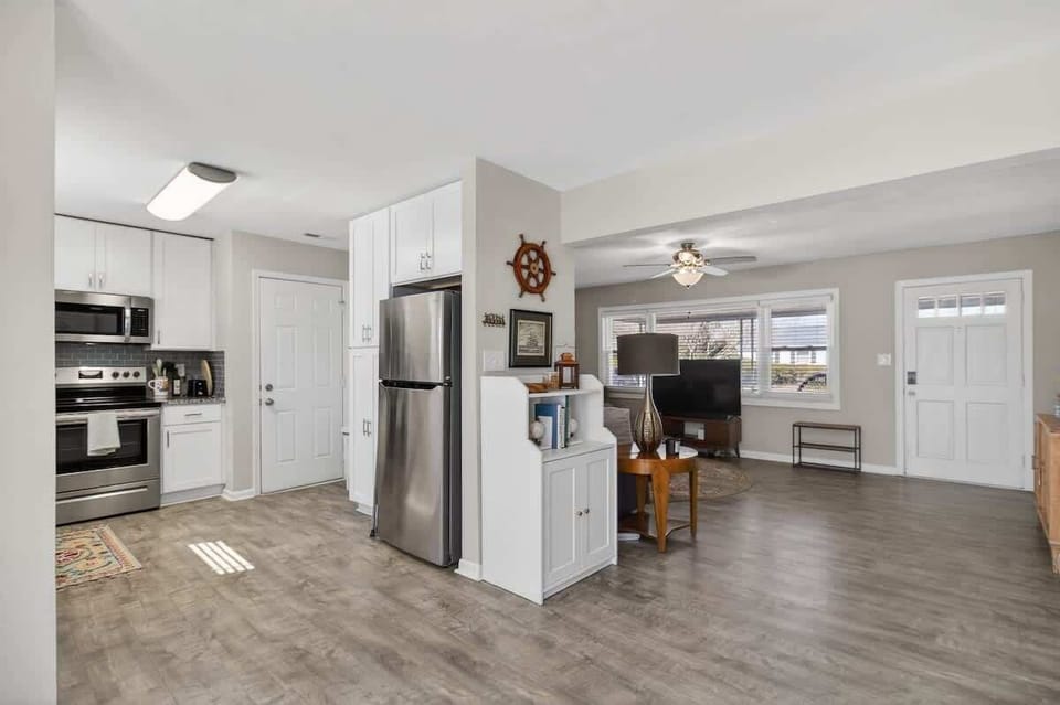 Updated kitchen with white cabinetry and stainless steel appliances.