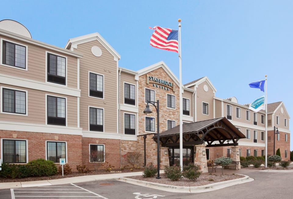 Welcoming property entrance with stone facade and American flags.