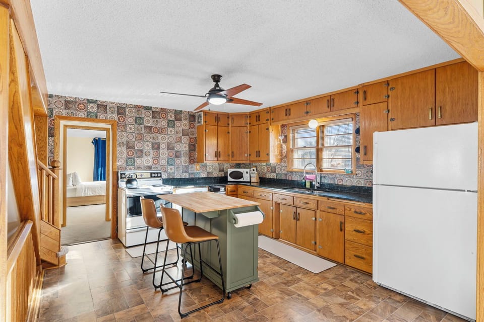 Your fully-equipped kitchen features warm wood cabinetry, granite counters, and a convenient island for cooking memorable meals together.