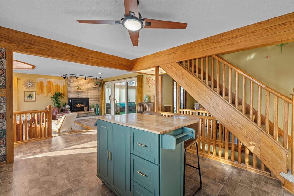 Your open-concept living space features warm wood accents, a cozy fireplace, and charming kitchen island perfect for gathering.
