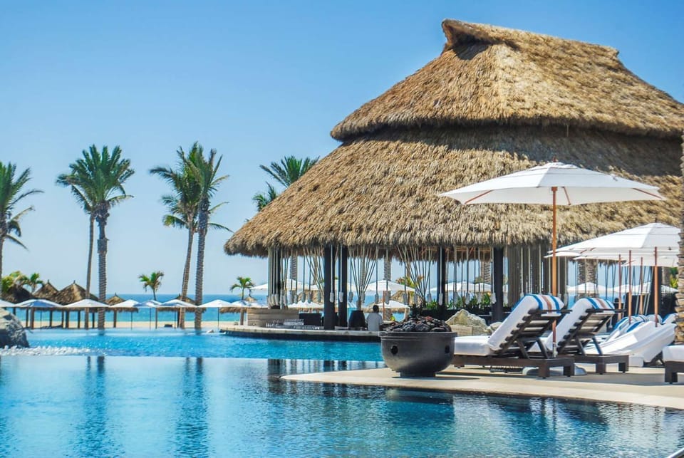 Sip poolside cocktails and lounge under breezy thatched shade.