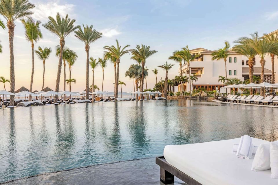 Unwind beside the palm-lined infinity pool at golden hour.