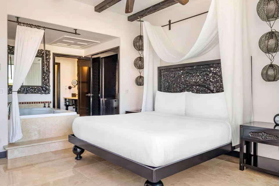 Lounge in crisp linens with breezy balcony views outside.