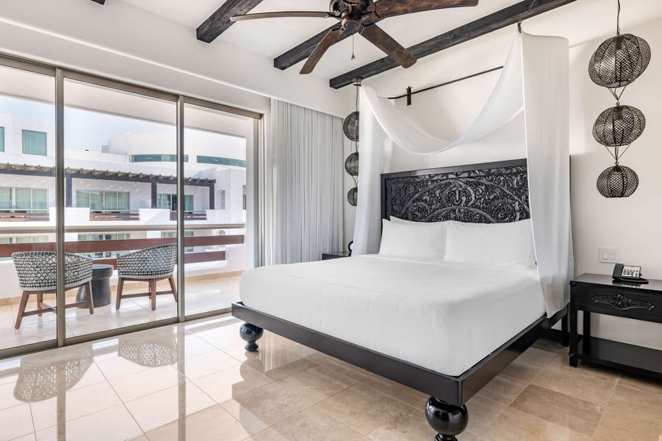 Wake gently in a breezy canopy bed beside the balcony.