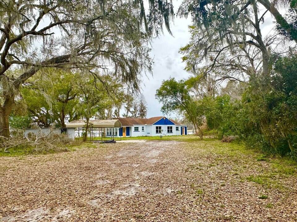 This charming teal lakeside ranch-style home blends vibrant character with laid-back waterfront living, offering the perfect backdrop for relaxing days by the water.