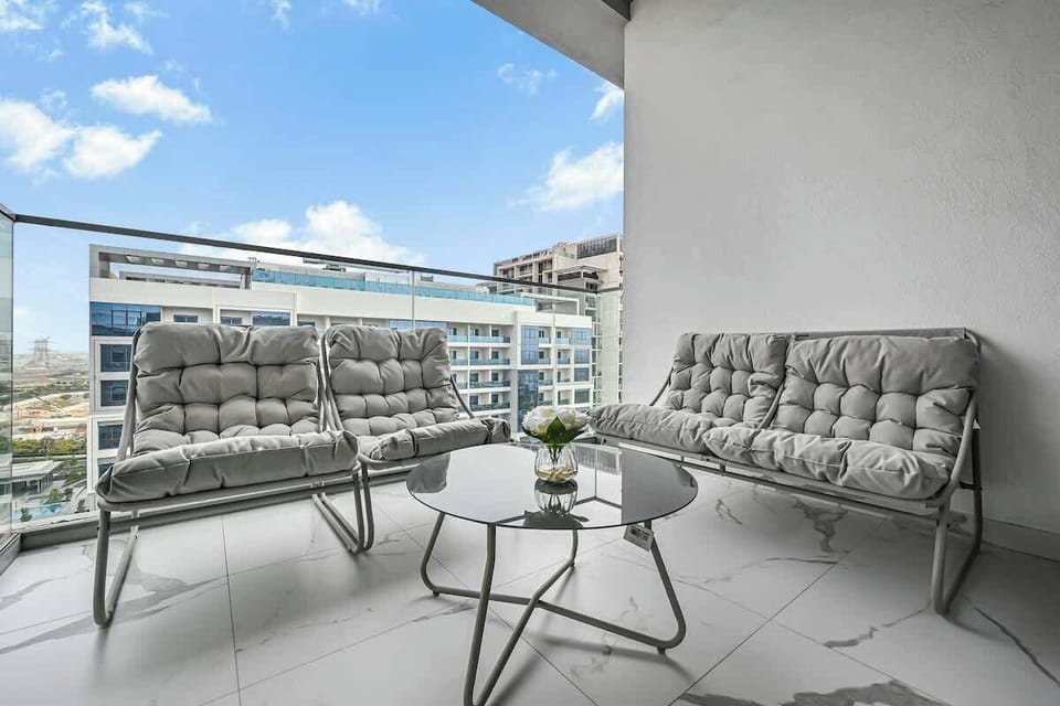 Unwind on the private balcony featuring cushioned lounge seating and a glass coffee table- perfect for morning coffee.