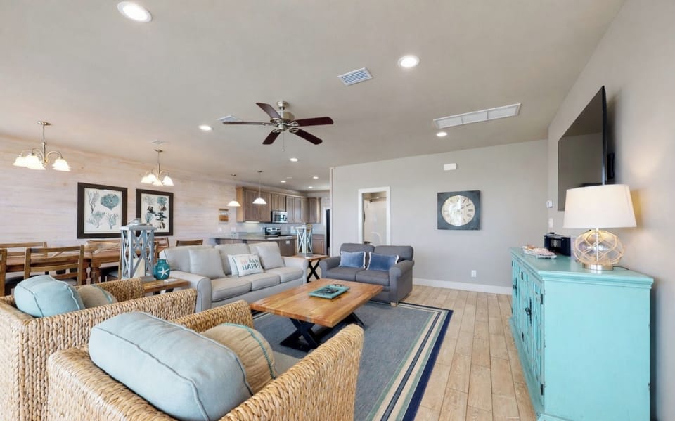 Living room area with plenty of seating and wall mounted Smart TV. Guests must log in to their own streaming services