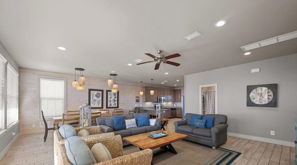 Living room area with plenty of seating and wall mounted Smart TV. Guests must log in to their own streaming services