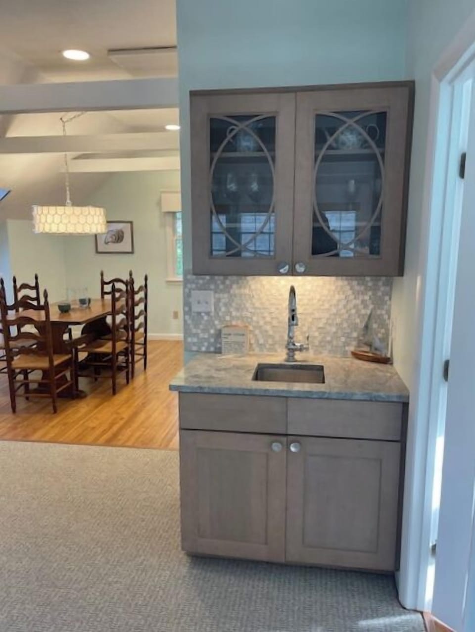 Wet bar in living room with kitchen beyond