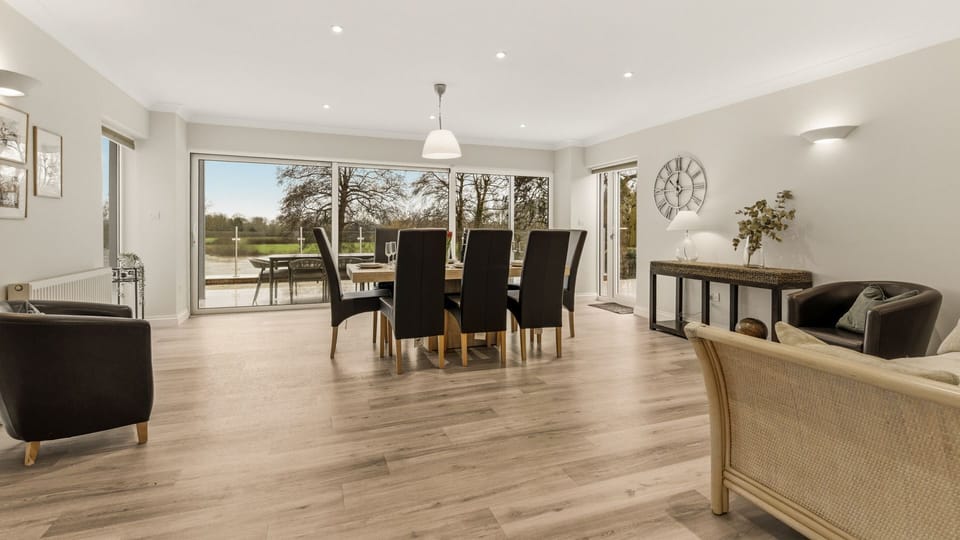 Making the most of the garden views, the dining table sits alongside sliding glass doors which open out to the terrace.