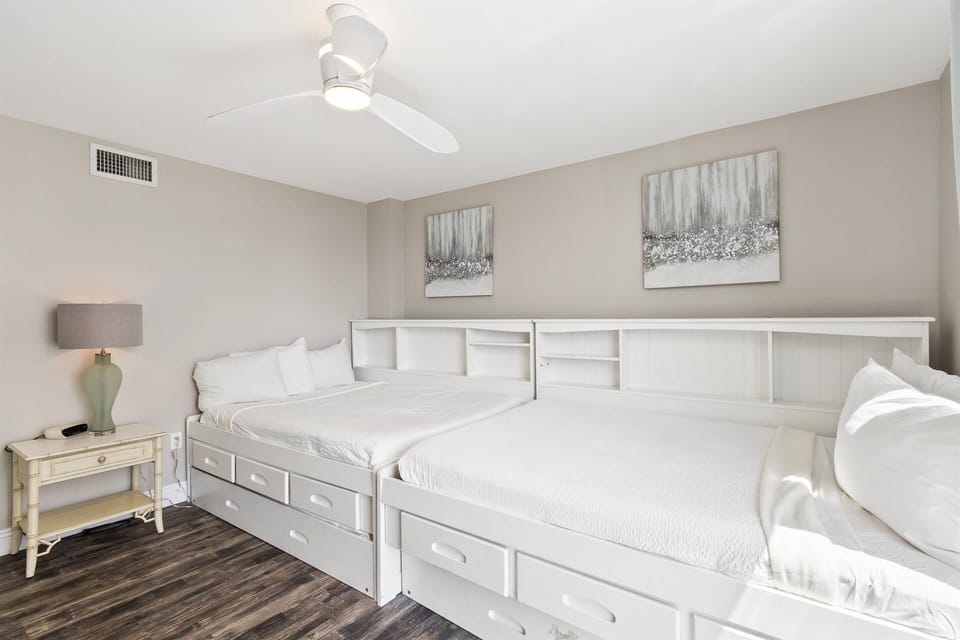 Sleep comfortably in this charming bedroom featuring twin beds with built-in storage and soothing neutral décor that creates your perfect retreat.