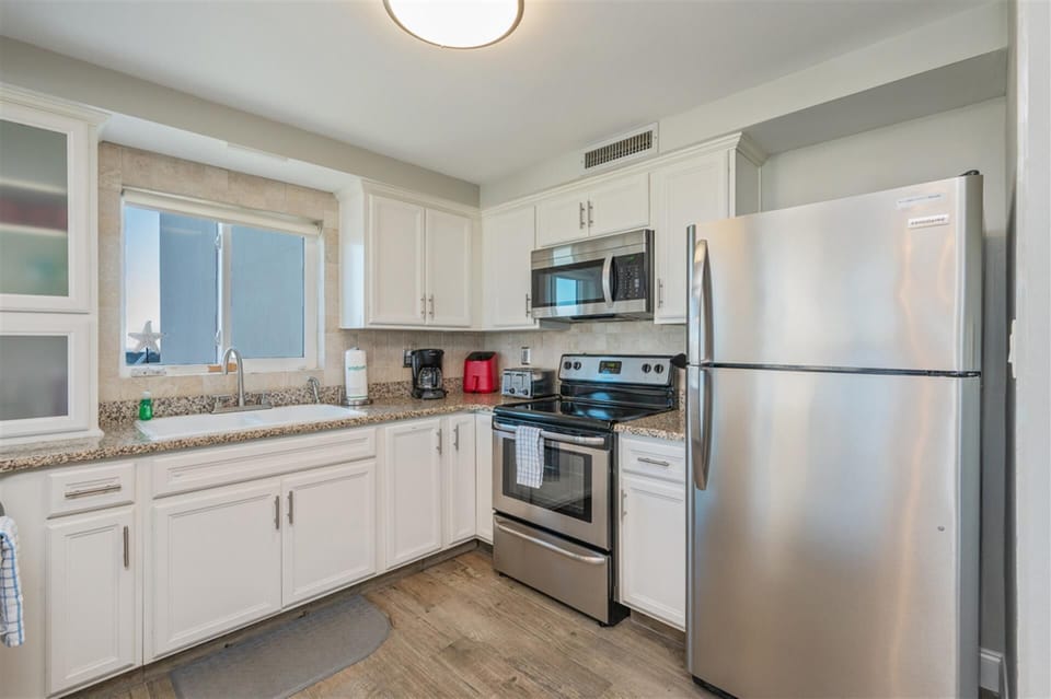 Your fully equipped kitchen features stainless steel appliances, granite counters, and bright natural light for preparing memorable meals during your stay.